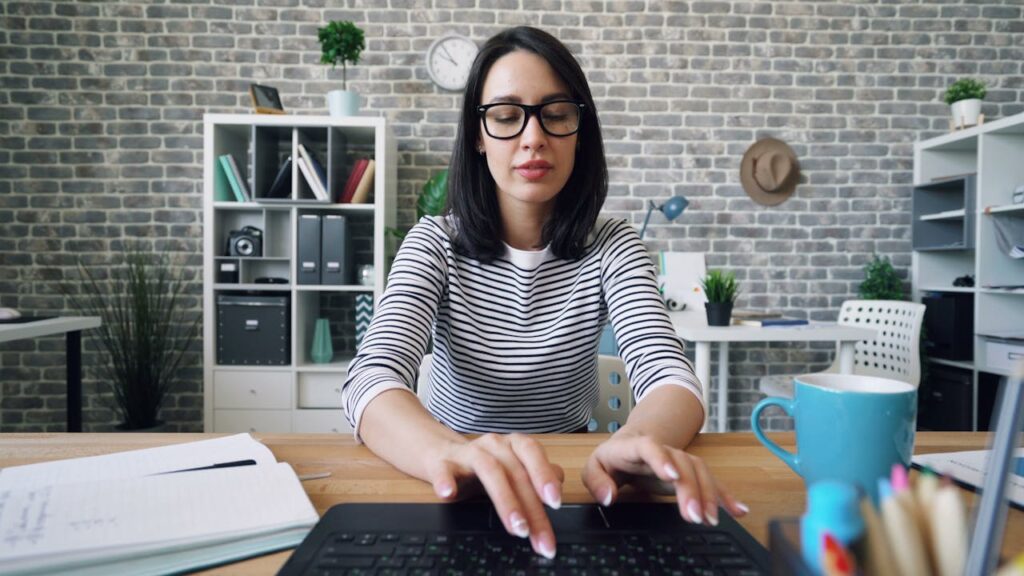 pexels-photo-22046240 A woman with glasses working diligently on her laptop in a stylish office environment.